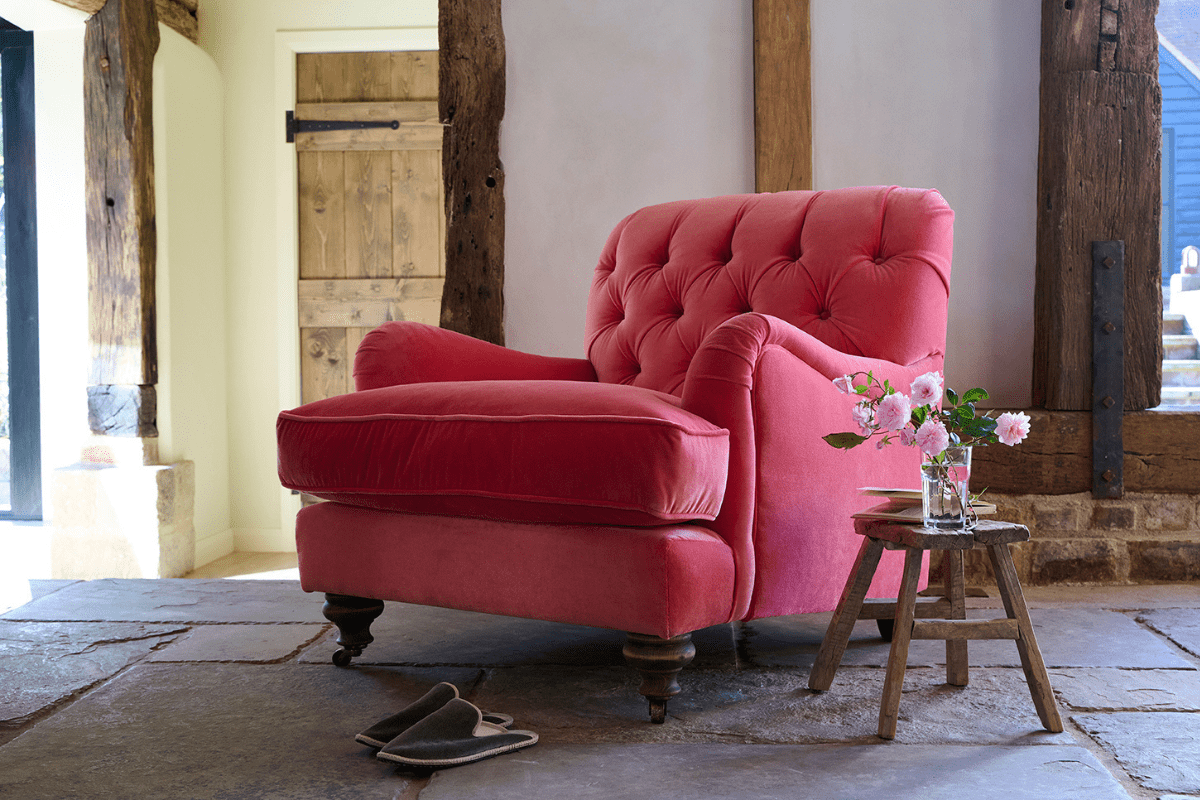 A chair in a vibrant pink fabric with light pink flowers 