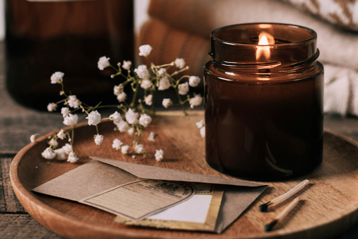 An autumn lit candle on a wooden tray