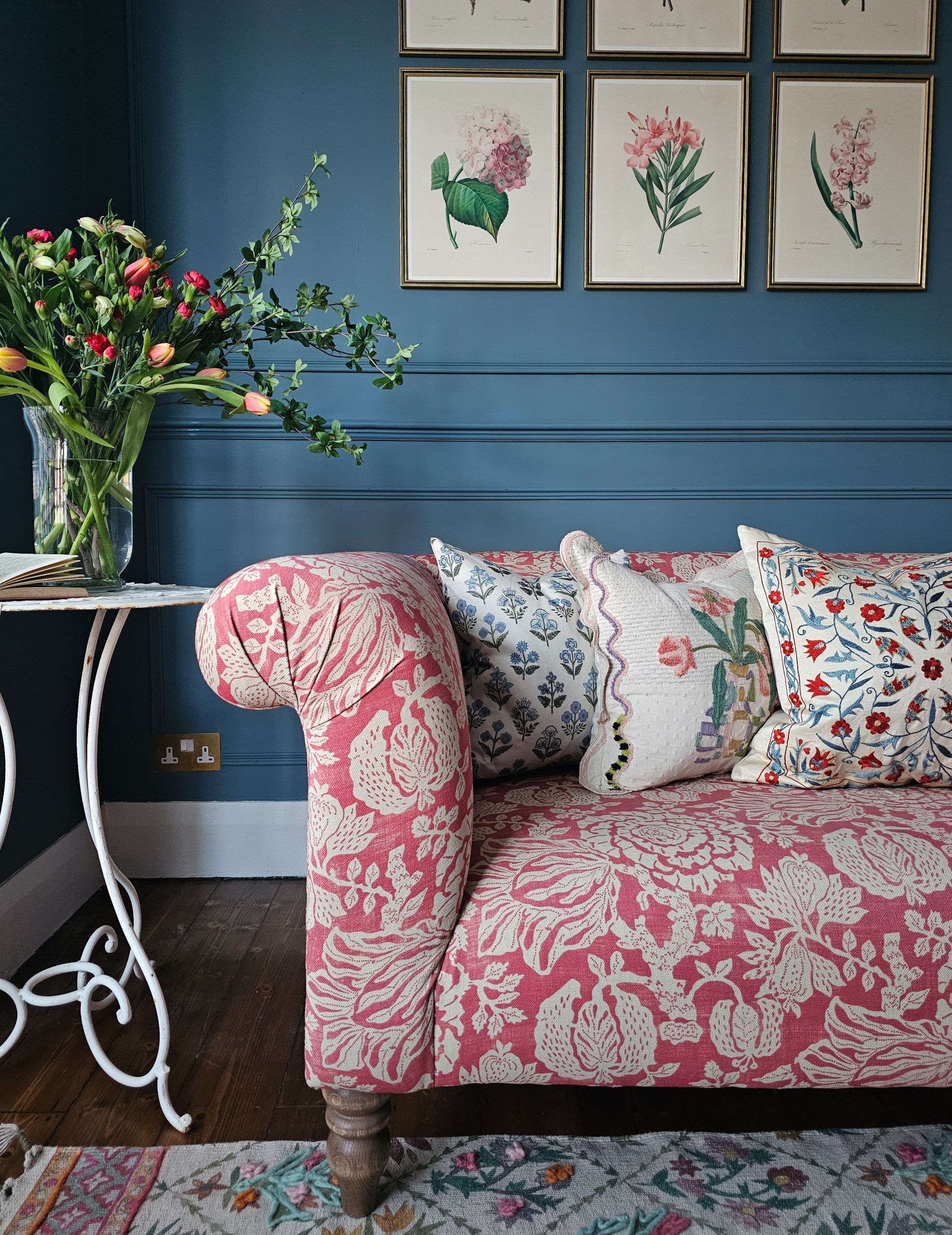 An image of a red patterned sofa in a blue living room.